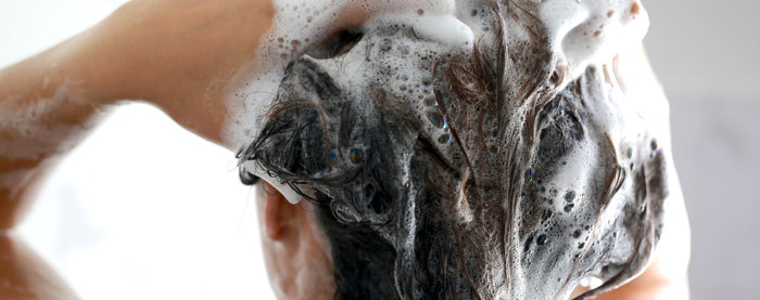 De la mousse de shampoing dans les cheveux