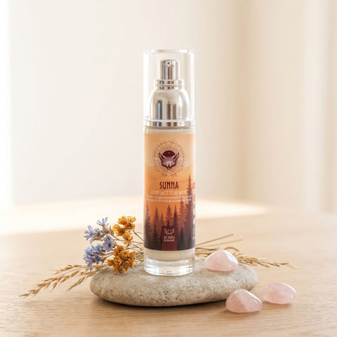 Sérum éclat Sunna à l’abricot en flacon compte-gouttes, posé sur une pierre avec des fleurs séchées